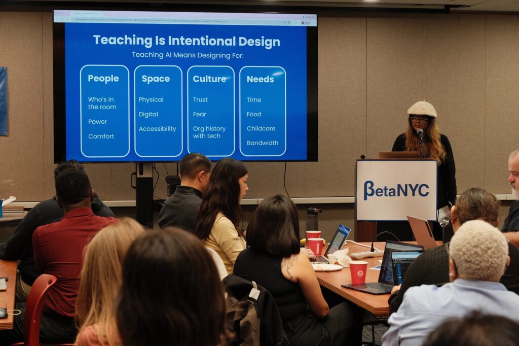 A slide titled “Teaching Is Intentional Design” lists four things to design for: people, space, culture, and needs. Naeema Haque speaks from the lectern.