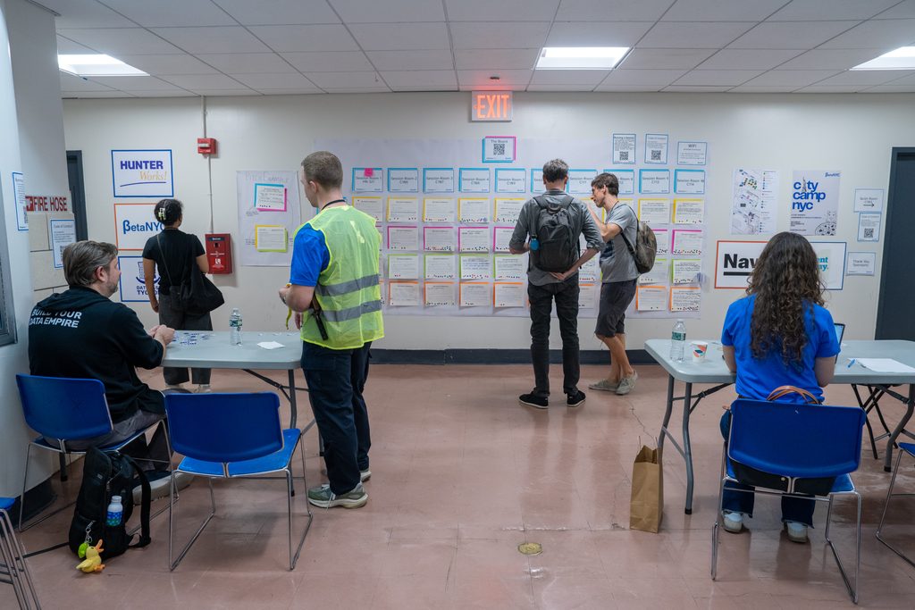 Attendees browse The Board, a wall of session cards organized by room and time.