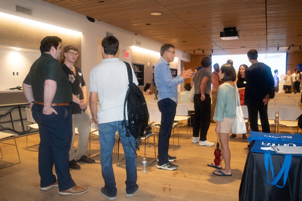 Attendees talking and networking in the event room after the showcase.