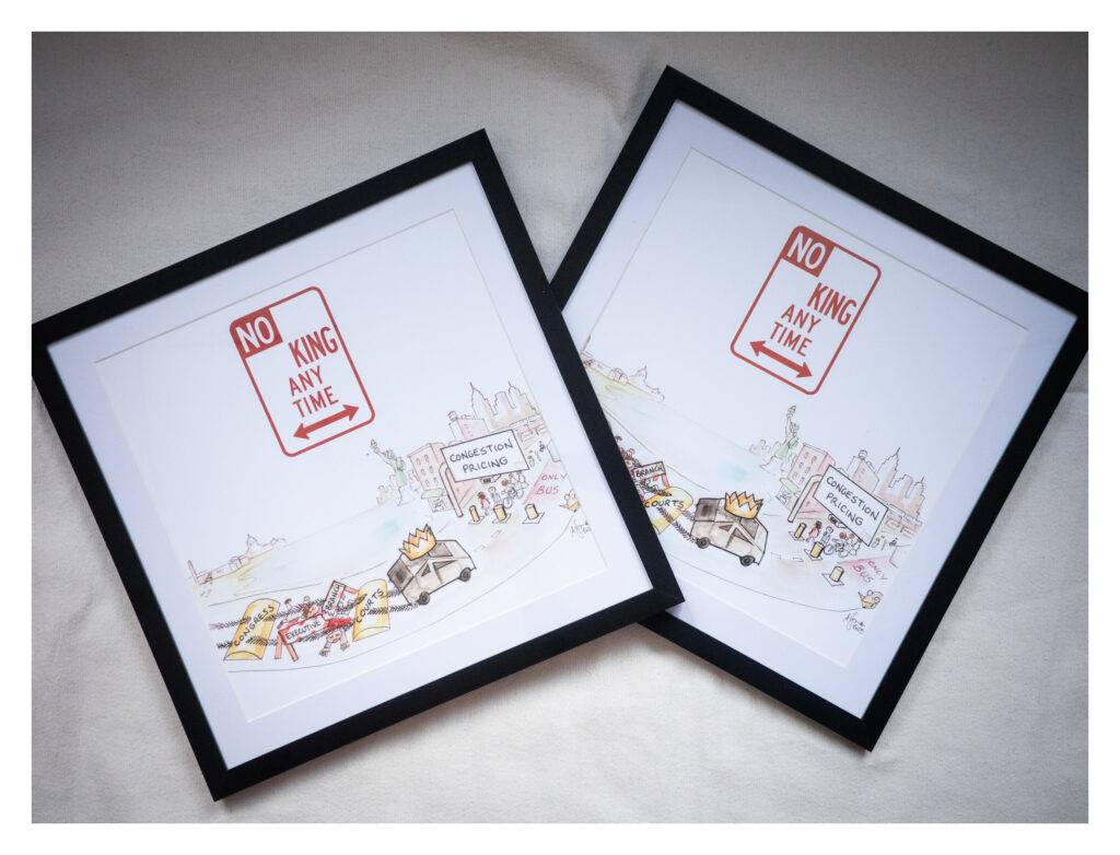 Two semi-gloss paper prints lie on a white background and are enclosed in black frames. Each print reads “NO KING ANY TIME," and is shown alongside hand-drawn cityscape graphics—streets, buildings, and cars—suggesting a civic, community-focused design aesthetic.