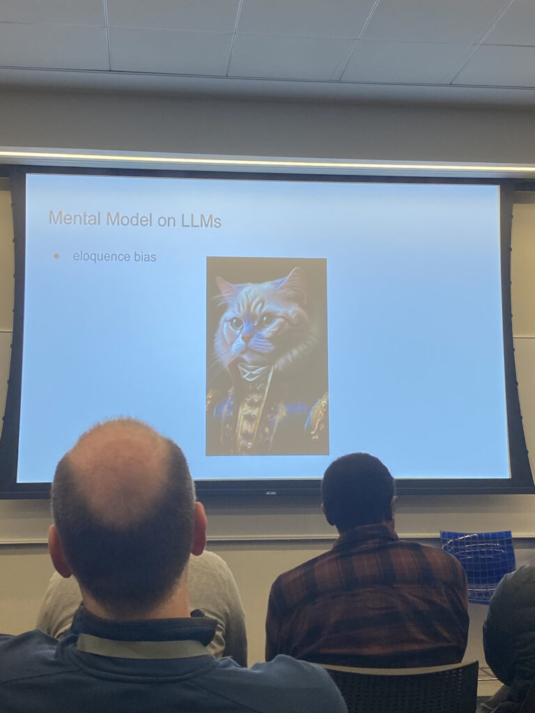 Soumith Chintala’s presentation including a meme of a cat to portray eloquence bias in Large Language Models (LLMs).