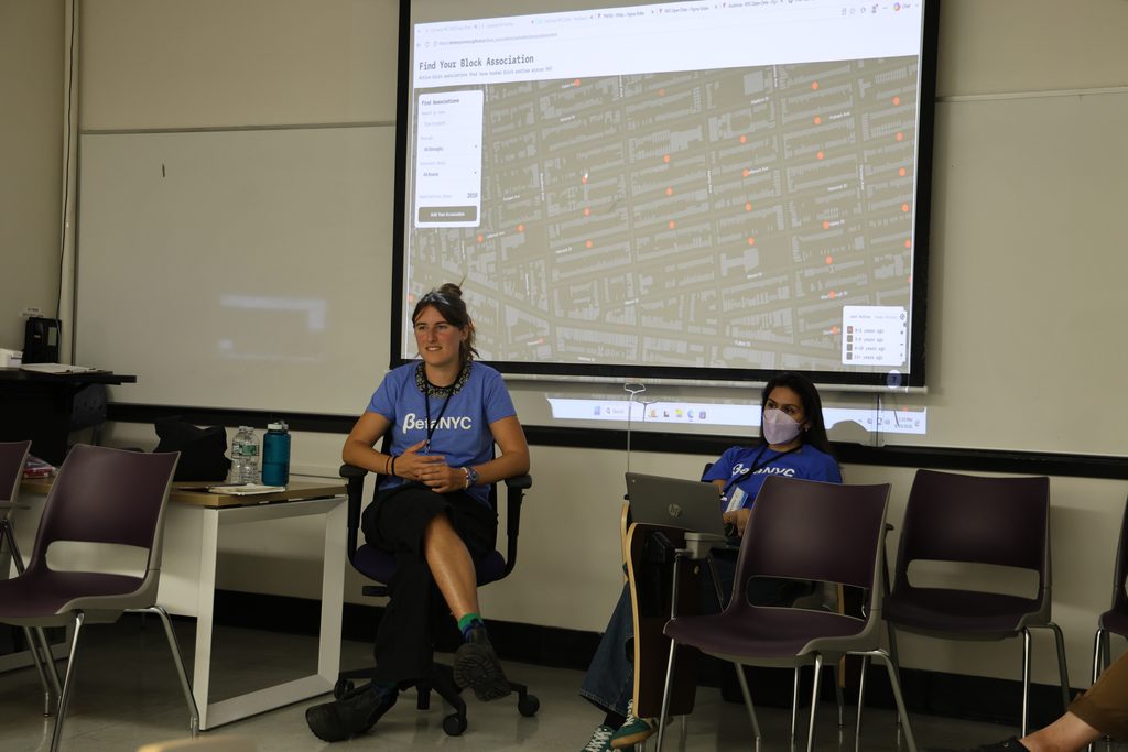 A session leader sits in front of a projected "Find Your Block Association" map.