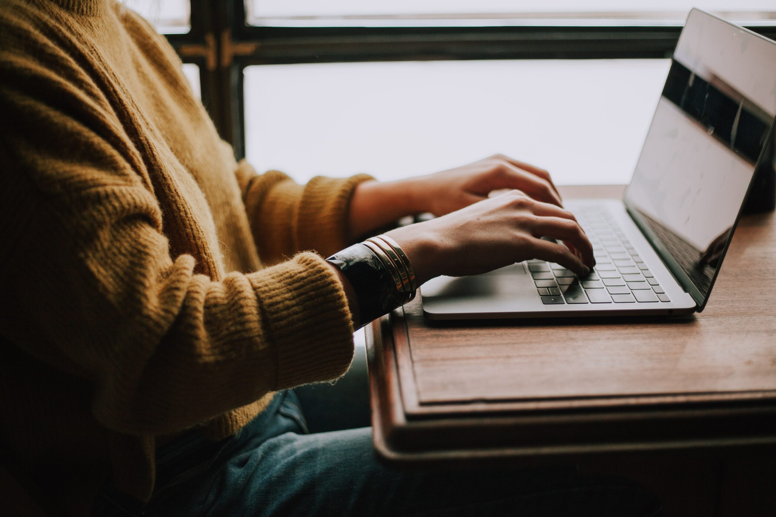 person sitting front of laptop typing